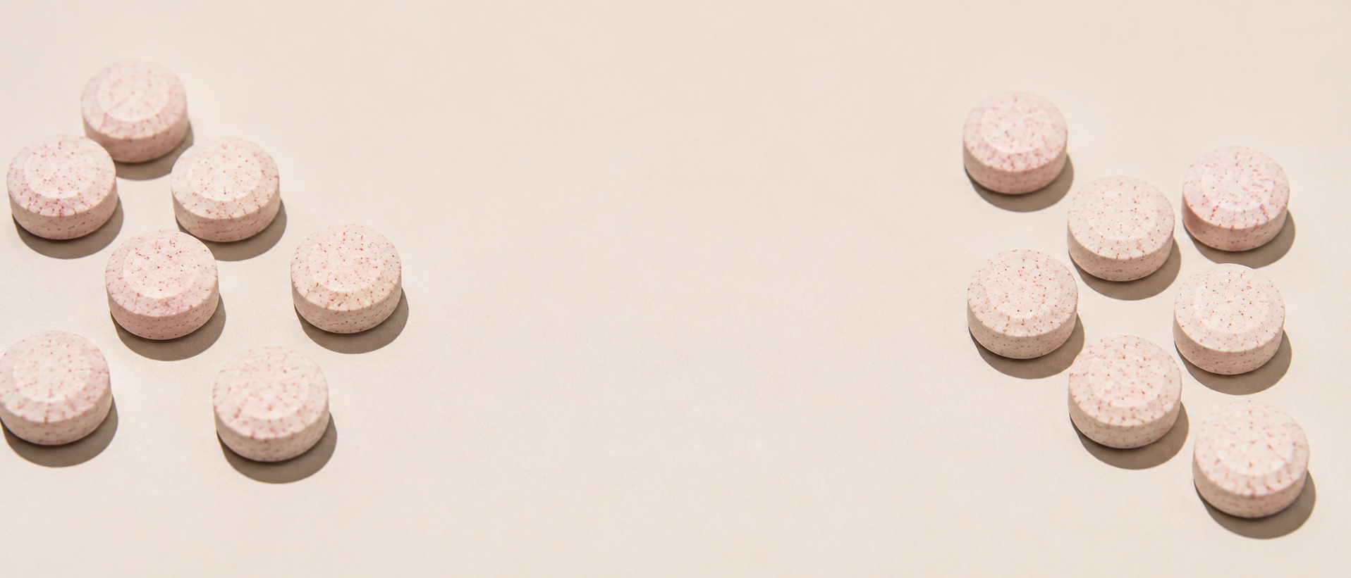 Blush-pink tablets arranged in two groups